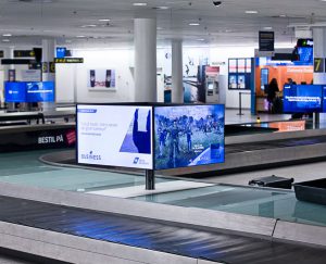 Ved baggagebåndene er der også placeret digitale skilte i form af mindre kuber med enkeltskærme på alle fire sider, hvorfra der vises reklamer og budskaber til de senest ankomne.