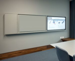 Skærme og whiteboards i mødelokalerne er integreret i én og samme løsning, hvor alle kabler er skjulte så intet hænger løst, hvilket giver et yderst enkelt helhedsindtryk.
