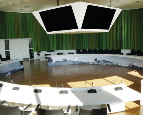 Hjørring Kommunes byrådssal er et imponerende syn. Den indbyggede skærmløsning der er monteret i loftet kan hæves og sænkes efter behov.