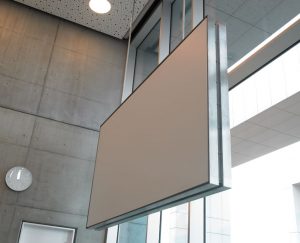 Rammelærredet i auditoriet er lofthængt og passer ind i den stramme og stilrene arkitektur